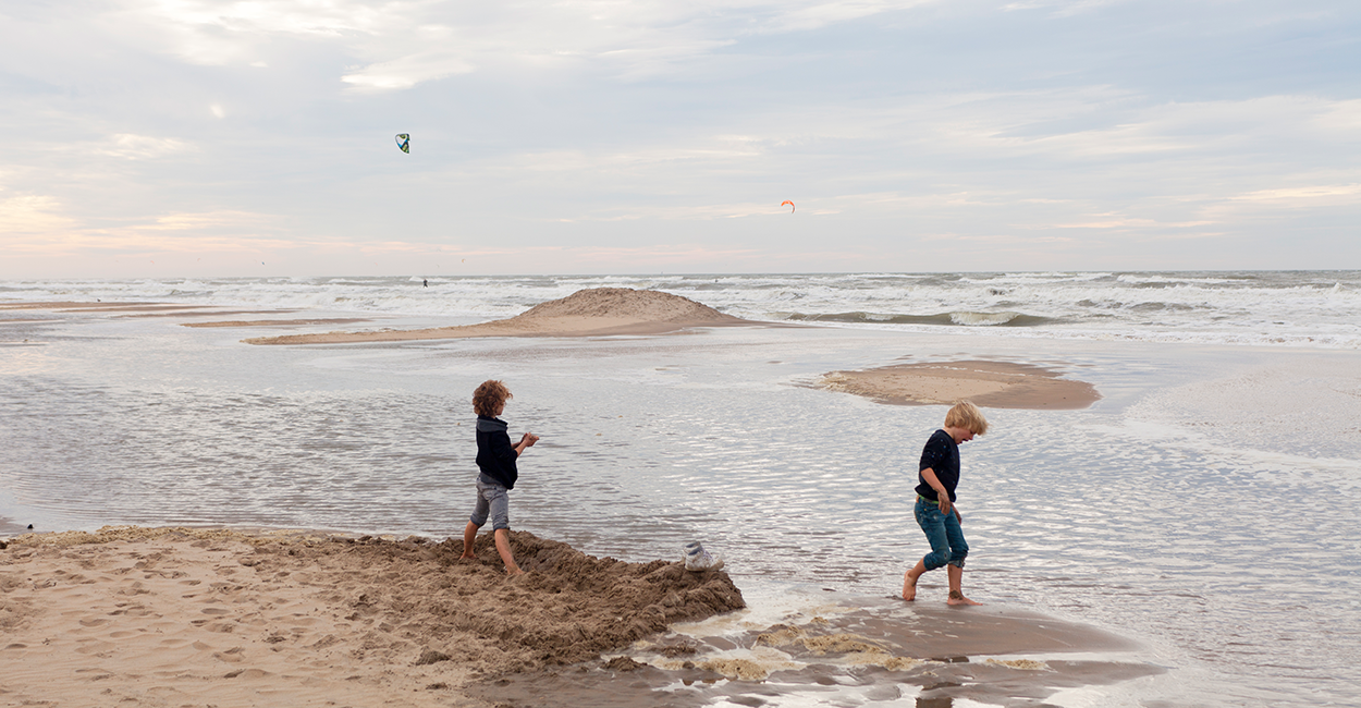 2 jongens spelen in branding strand Zandvoort